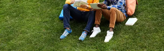 Pessoas sentadas na grama sintética
